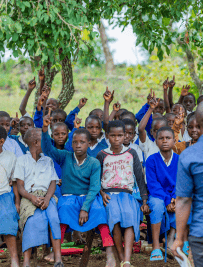 Students raising hands during an outdoor lesson 